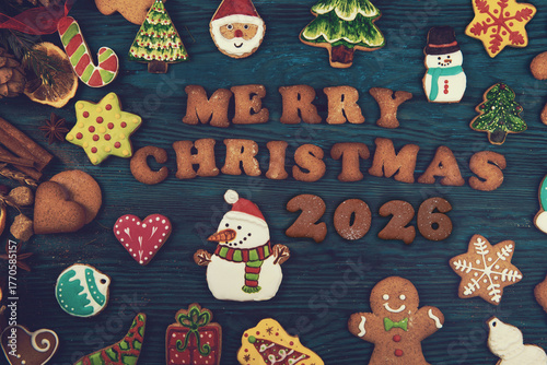 Colorful Christmas cookies shaped like snowmen, trees, stars, and gingerbread surround the text Merry Christmas 2026 on a wooden background.