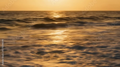 Golden Sunset Reflecting on Ocean Waves and Sandy Beach