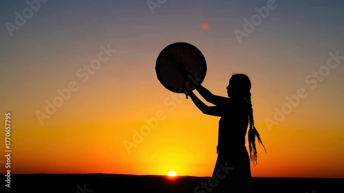 silhouette of woman with traditional shaman drum at vibrant sunset. spiritual ritual celebrating indigenous culture, heritage, and harmony. web design, book cover, banner with copyspace.