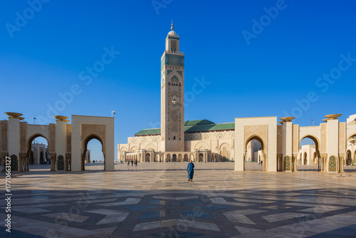 Courtyard of a grand mosque with intricate architecture under a clear blue sky. Casablanca, Morocco