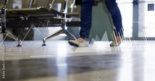 Walking traveler pulling light green suitcase across floor at airport with chairs and data overlays