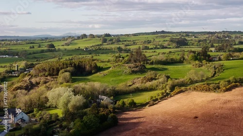 From above, you can see green fields and farmland divided by hedges, under a sky that is partly cloudy, in rural West Cork, Ireland.