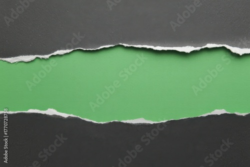 Ripped paper with green hole in black sheet texture background