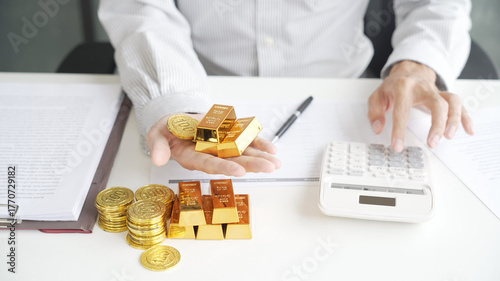 Gold Trading Businessman invest in trading gold, calculating profit price for buy and sell gold in stock market when price dropping rapidly.