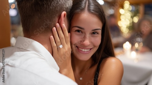Intimate moment of a couple embracing after a proposal in a candlelit restaurant, her eyes sparkling with tears of joy. Diamond ring in focus, warm and cozy atmosphere. 
