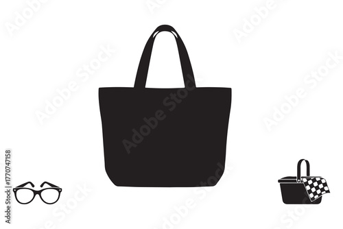 Black canvas tote bag with glasses and picnic basket isolated on white background