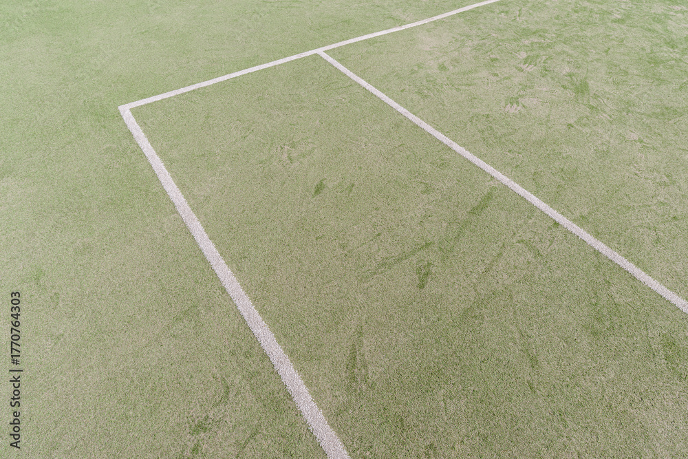 Obraz premium Artificial green turf with white painted lines on a open sports field