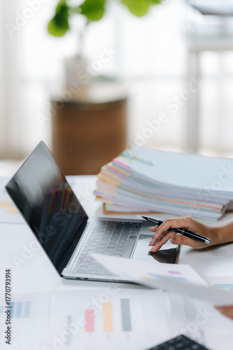 Working on Data: A modern workspace where an individual processes reports, analyze trends, and organizes data on a laptop. Focused, effective, efficient, and well-organized.