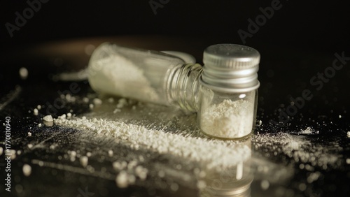 Illegal drug in powder in glass vial, substances abuse. Opioids and fentanyl crisis. Drug heroin, or crushed oxycodone packed in the bottle. Addicted people using for snorting.