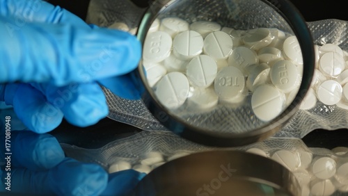 Schilderij op canvas Police investigator in blue gloves studying seized illegal drugs packed in vacuum bag