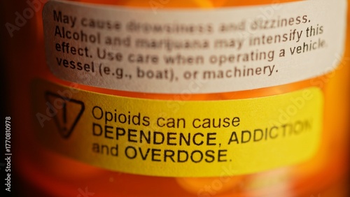 Prescription bottle full of pills with warning stickers saying, Opioids can cause dependence, addiction and overdose. Do not chew or crush before swallowing.