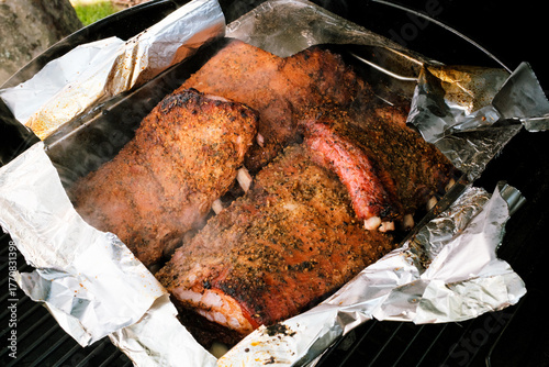 Geräucherte und geschmorte St. Louis Cut Ribs (fleischige Bauchrippen vom Schwein), in Edelstahlbräter mit aufgerissener Alufolie