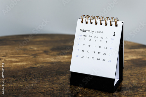 February 2026 monthly calendar page on a wooden desk, minimal design planner representing time management and organization at workplace