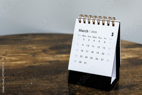 March 2026 monthly calendar page on a wooden desk, minimal design planner representing time management and organization at workplace