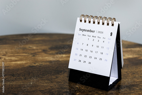 September 2026 monthly calendar page on a wooden desk, minimal design planner representing time management and organization at workplace
