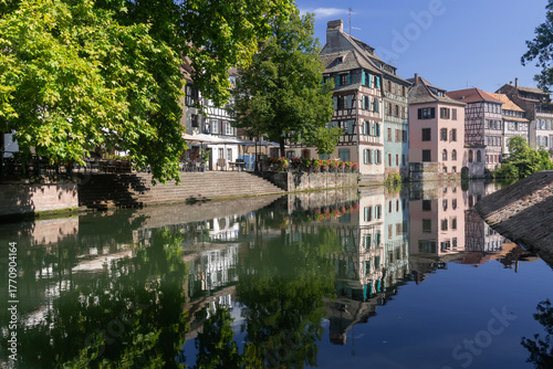 Strasbourg, France - August 26th 2025 : View of the Tanner's Quarter with half-timbered buildings and the Ill river and reflections on the water.