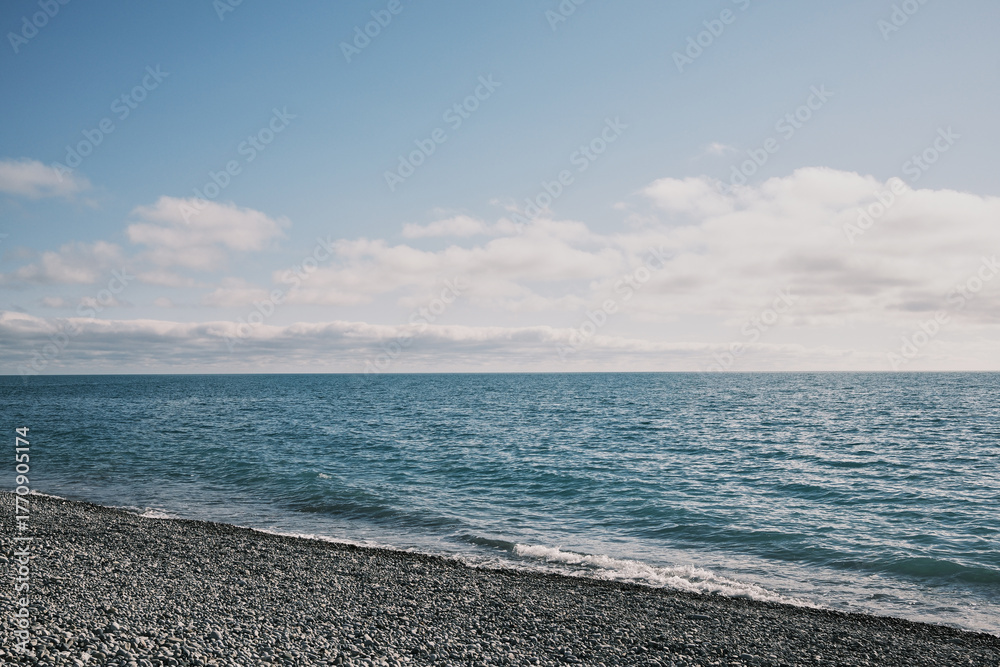 Obraz premium Wide seascape with calm blue water and clouds above the Black Sea horizon, Russia