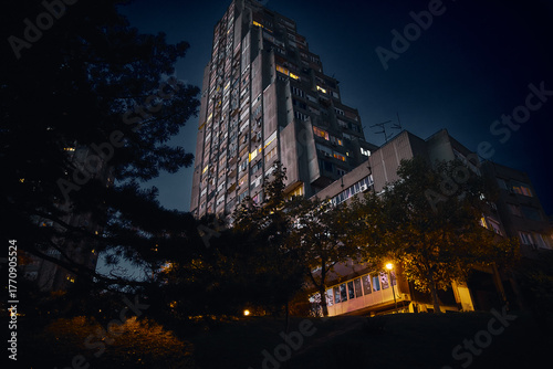 Night city: a high-rise building with streetlights and trees in a city park. Belgrade, October 19, 2025.