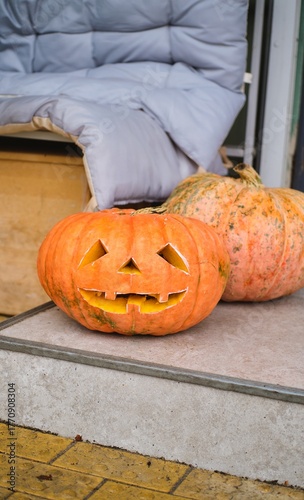 A carved Jack-o'-lantern on the street outside a cafe. Happy Halloween.