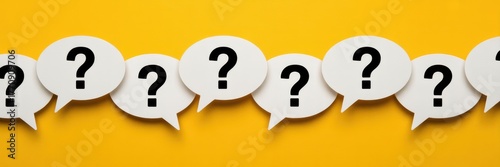 Series of white speech bubbles with question marks on a bright yellow background, representing inquiry and uncertainty