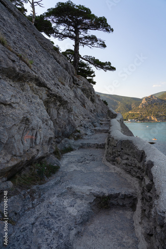 Stone path against the sea and mountains at sunset