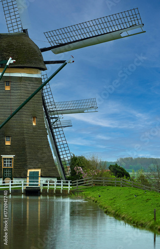 Windmill on the canal in peaceful Dutch countryside