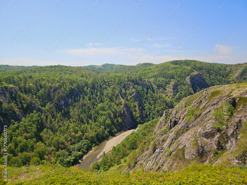 Fototapeta premium Magnificent mountainous landscape with lush greenery, river, and clear blue skies. nature's perfect harmony and the breathtaking serenity of untouched wilderness landscapes.