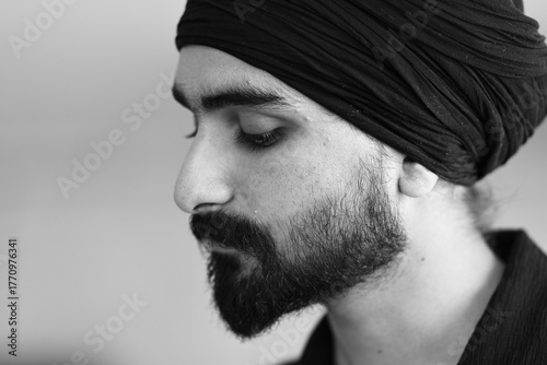 Fotografi Close up of a bearded man wearing a turban with his eyes closed in contemplation