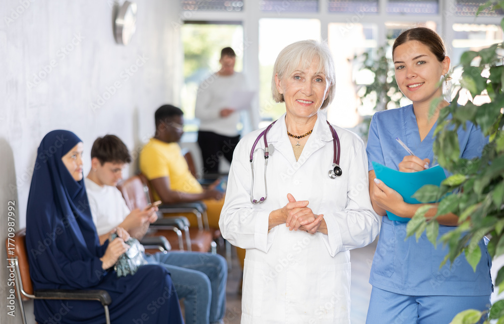 Fototapeta premium Portrait of an experienced female doctor and a young nurse in a medical clinic