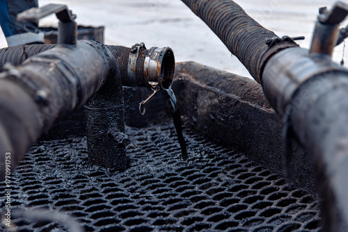 Close-up of industrial pipes with crude oil. oil and gas production concept