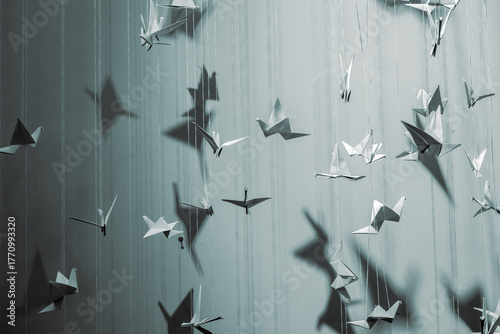 Wallpaper Mural paper origami birds tied to strings hanging in air against a black background. The paper origami birds vary in size and orientation, creating a dynamic, three-dimensional effect Torontodigital.ca