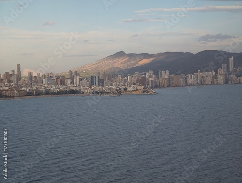 Photography serene shoreline with highrise reflections, calm oceanfront with sunset reflecti