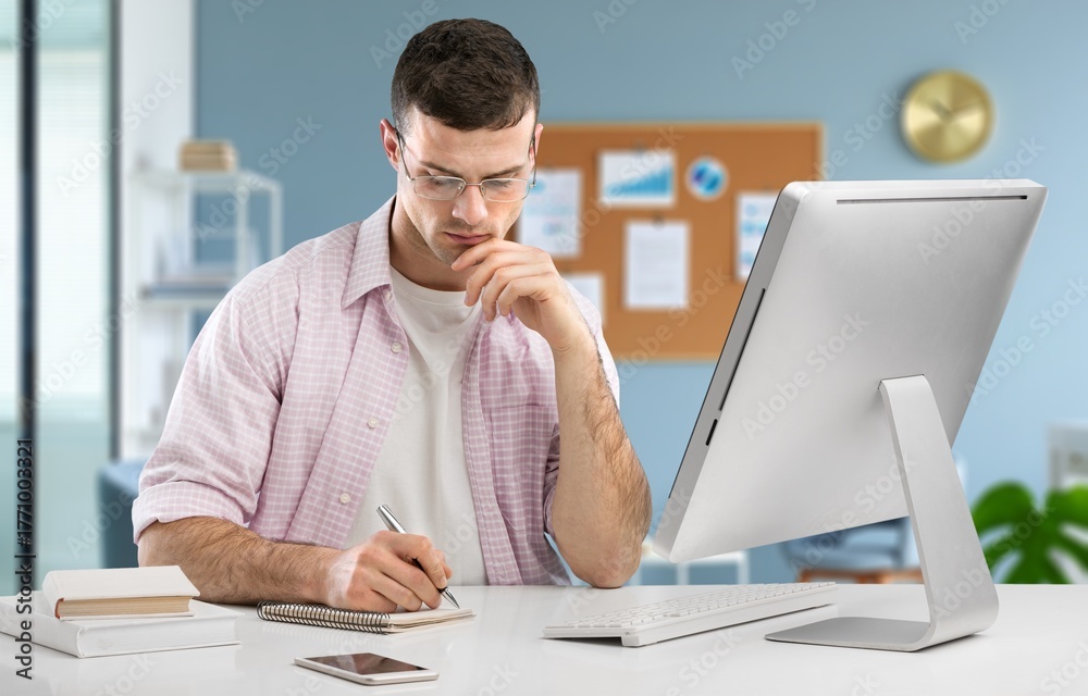 Naklejka premium Smart businessman thinking with computer in office