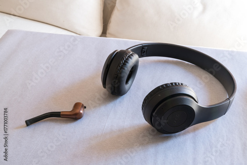 Wireless headphones and a mint smoking pipe on white paper