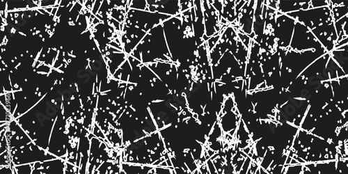 Abstract black and white grunge texture with chaotic scratches, lines, and splatters on a dark background.