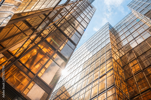 Looking up at the modern golden building facade from a low perspective
