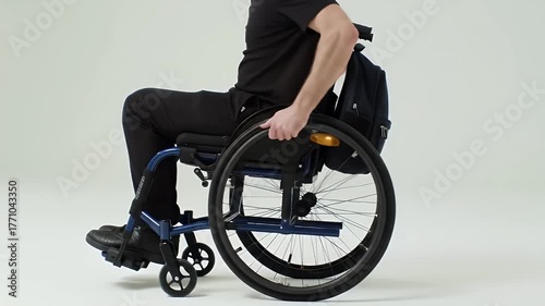 Side View of Man Seated in Blue Wheelchair Against White Background