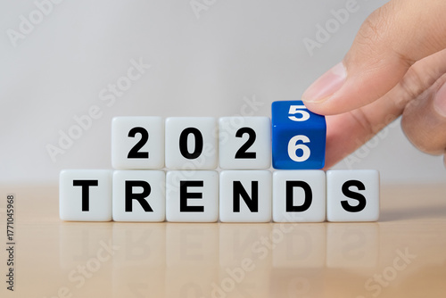 Hand flipping dice to change from 2025 to 2026 trends for business , fashion and technology trend change concept after new year.