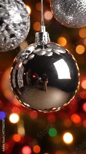 Glittering silver ornaments suspended against colorful bokeh background