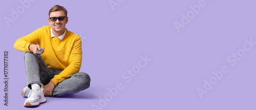 Happy young man with remote...
