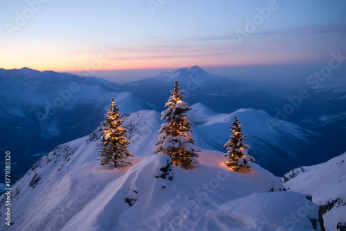 Snow covered evergreen trees on a mountain peak at sunset