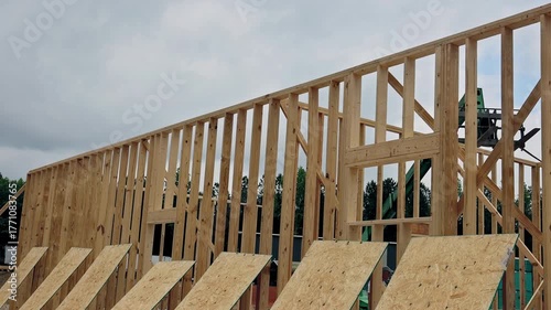 Workers are building wooden beams frame structure at construction site