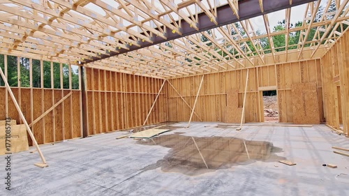 Wooden beams frame construction site with concrete floor, early stages of building