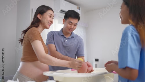 Pregnant woman and husband learn to bath baby at maternal health center. 