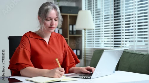 Successful businesswoman in modern office working on laptop.for doing math finance on an office desk, tax, report