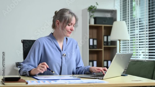 Successful businesswoman in modern office working on laptop.for doing math finance on an office desk, tax, report