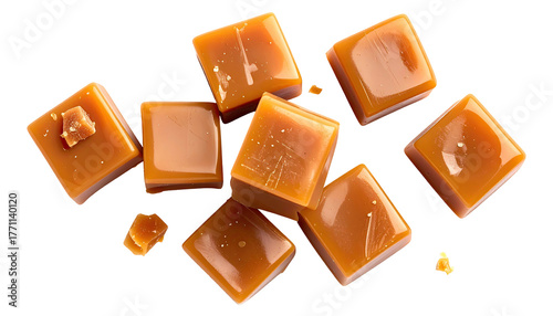 Glossy, caramel-colored cubes scatter on a dark, stark background