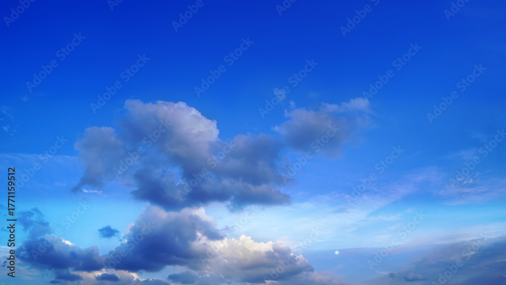 Obraz premium Clear blue sky with fluffy white clouds on a bright sunny day