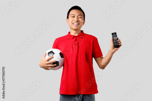 Young Asian man with remote...