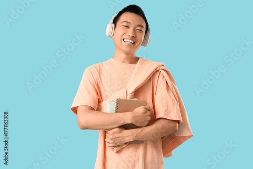 Young Asian man with notebo...